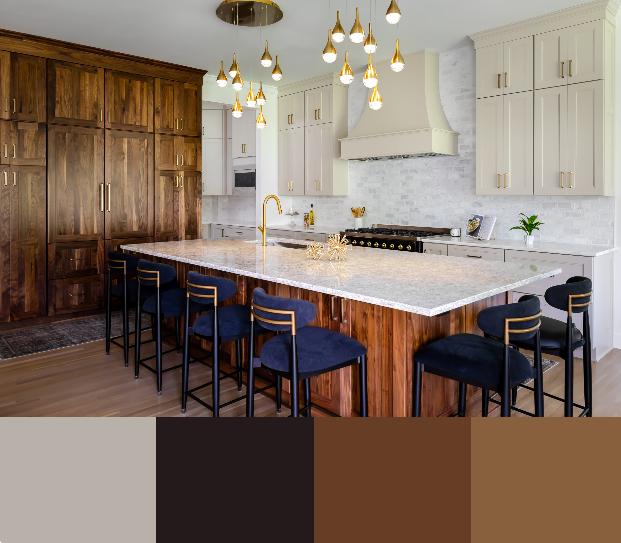 A modern kitchen with a large marble countertop island and a mix of white and dark wood cabinets. The island features a waterfall edge and counter-height seating with plush velvet blue bar stools. Gold accents are featured in the lighting and hardware.