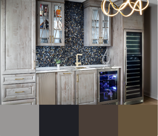 A modern wet bar with a wine cooler, a sink, and glass-front cabinets. The cabinets are a light gray color with gold hardware. The backsplash is a dark blue mosaic tile.