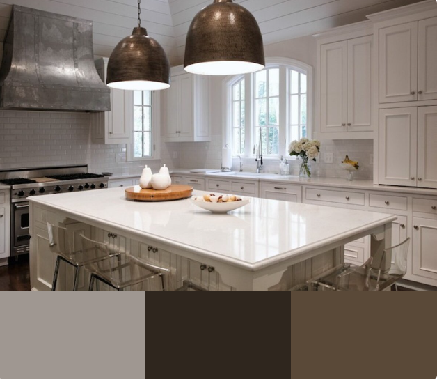 A bright and airy kitchen with white cabinets, a large white quartz countertop island, and a farmhouse sink. The backsplash is a white subway tile, and the range hood is a copper-colored metal.