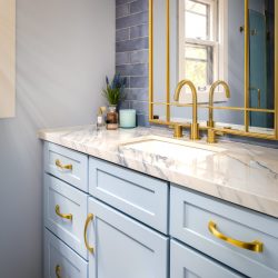 Light blue bathroom vanity with gold hardware.